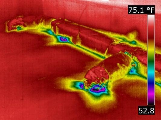 Infrared image depicting cool air leaking from distribution ducts located in an unconditioned attic...