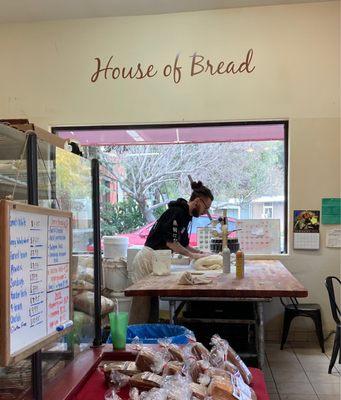 Bread being made live - baker measures out dough for loaves