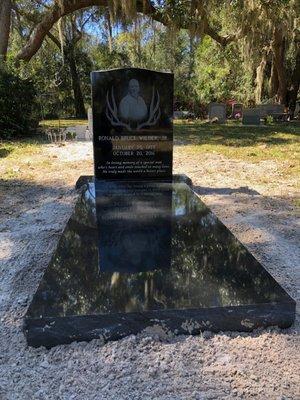 Black granite single upright and base with matching ledger (grave cover)