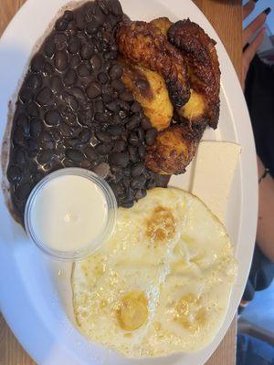 Over med eggs with plantains & black beans. Served with crema & tortillas.