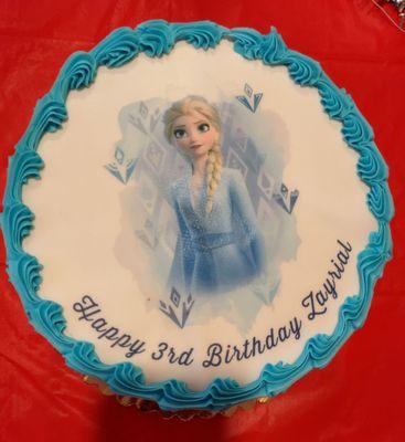 HugeONER  Happy Birthday Round white cake with  Elsa.       white cake with fresh strawberry & bananas as filling.