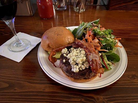 Burger with blue cheese and baca on with a side salad.