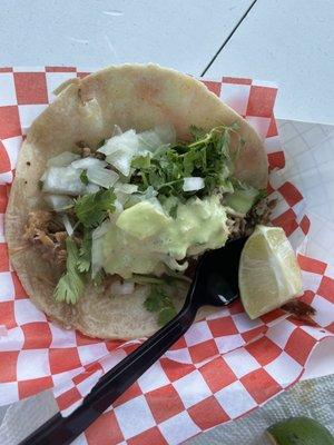 Taco de carnitas on a corn tortilla.