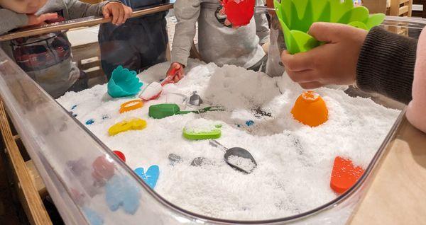 Ice and Cold theme: Children play with artificial snow in the sensory bin