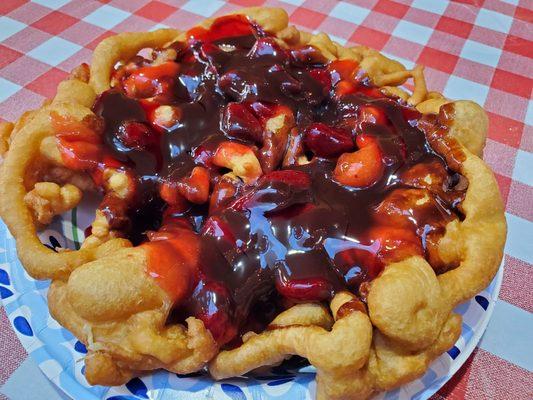 Funnel cake with chocolate sauce and strawberry topping