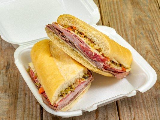 Muffuletta sandwich with Swiss, ham, pastrami, salami, and provolone topped with an olive salad on fresh baked Cuban bread