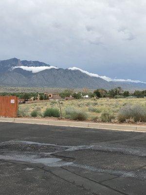 View of clouds peeking behind the mountain.