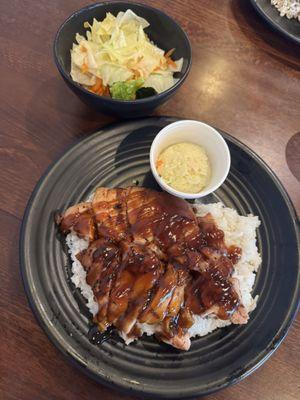 Teriyaki chicken plate on a bed of steamed rice with a side of potato salad and steamed veggies.