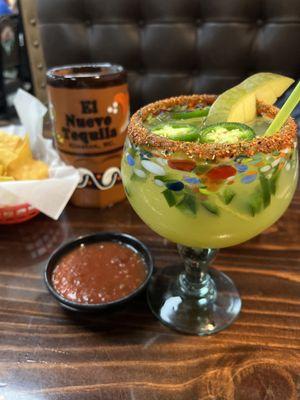 Spicy margarita, salsa and chips and a beer in the background