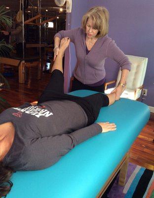 Owner,Mary-Jane Amrein is helping a client with leg muscular pain using Muscle Activation Techniques