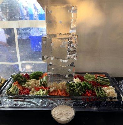 Ice sculpture of dice with ice platter and assorted vegetable crudites.