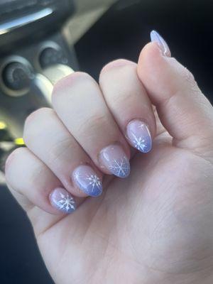 Nail manicure description: pink to blue fade with sparkles, overlaid with white painted on snowflakes.