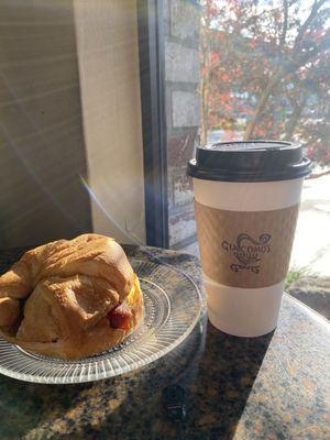 Egg bacon and cheese croissant paired with a 16 ounce coffee with oat milk.