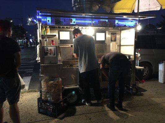 Grill master cooking up my hot fresh order of a squid skewer and fish balls.