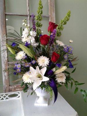 Elegant  splendor,  Casablanca lilies, white stock, cushion mums, purple montecasino, red roses, and bells of Ireland