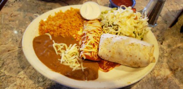 Combination plate with Al pastor enchilada, carnitas burrito, ground beet tostada, sour cream, rice and beans