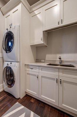 Laundry room white cabinet paints keep the room feeling fresh and clean.