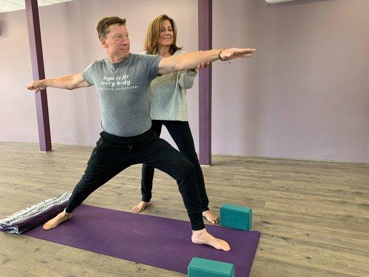 Yoga Home Teacher Rose DiSanto helps Brian find his Warrior 2 posture.