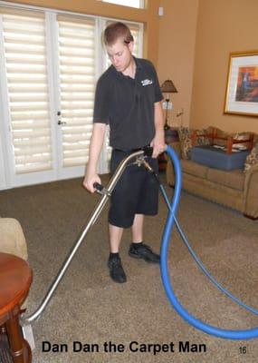 Dan Dan the Carpet Man technicians carefully clean around larger furniture pieces that remain in place.