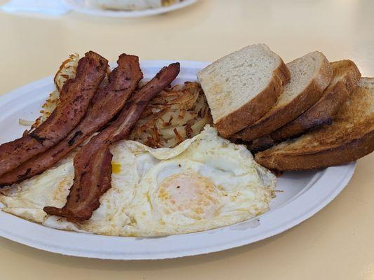 Two Egg Breakfast includes: two eggs (over easy), sourdough toast, and hash browns. Added: bacon