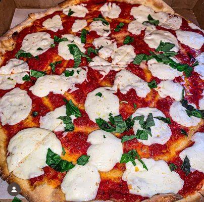 Fresh margherita pizza with fresh basil, and mozzarella