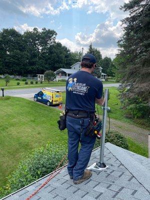 Technician installing new metering equipment through the roof to raise power line over the driveway