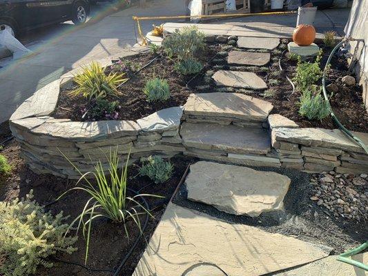 Stacked stone wall, stepping stone path and low water plants