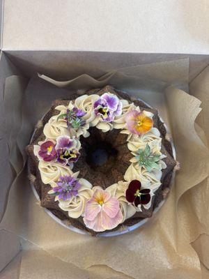 Cinnamon Bundt cake with maple frosting and edible flowers