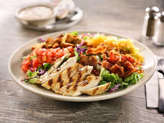 Chicken Club Salad - Tender chicken served on a bed of mixed greens with tomatoes, bacon, cheese, croutons and your choice of dressing.