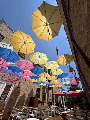 Vibrant patio with colorful umbrellas hanging over the seating area. Nice ambiance to Downtown Skokie!