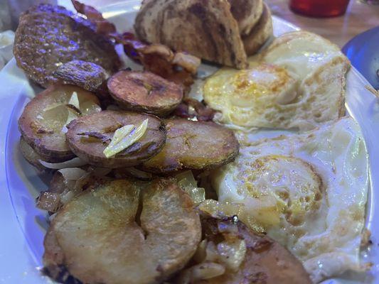 Two eggs, fried potato, sausage, bacon, rye, toast.