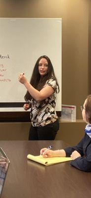 Kate working at the dry erase board.