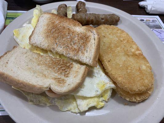 Scrambled eggs, sausage, hash-browns and toast