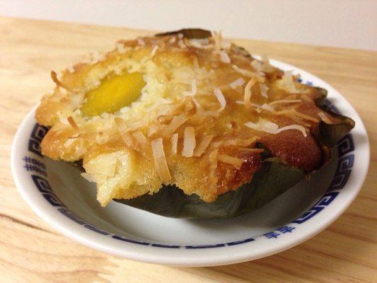 Bibingka up close; they're wrapped in banana leaves. The white strips are coconut, and the yellow is the salted egg.