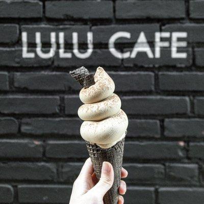 Earl Grey Milk Tea Poopie Soft Serve in front of the LULU Wall