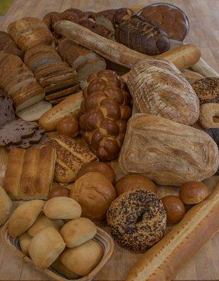 A pile of our most popular products, all made fresh without preservatives. Sliced sandwich loaves, artisan loaves, dinner rolls, & bagels