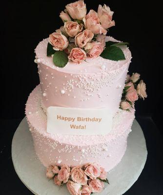 2 tier birthday cake with pink roses. Cake had layers of raspberry mousse and French vanilla butter cream  by delicious edibles