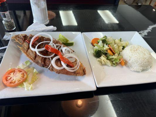 Fried red snapper and vegetables on the side with rice.