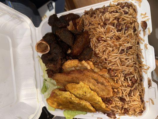 Fried goat, rice and beans, fried green plantains, side of salad.