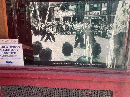 The Seattle Kung Fu Clubs front window with a photo of John SS Leong in the CID.