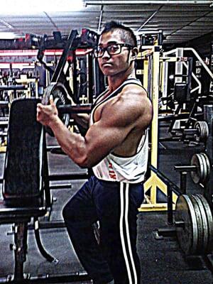 Mark Salameda at the Asylum Gym loading a plate on the iso decline chest machine. Former employee and lifelong member.