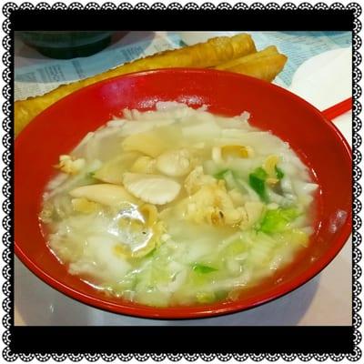 Flat noodles in seafood soup. Fried bread on the side.