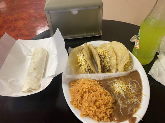 3 medium fried beef tacos with beans and rice and a  burrito.