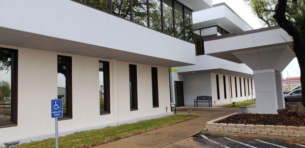 The office building, a nice modern office with nice large windows in the room where you get your teeth cleaned.