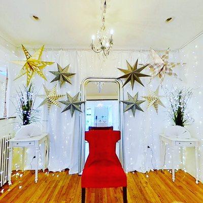 Bright white open space with festive lights, star decorations and a red chair