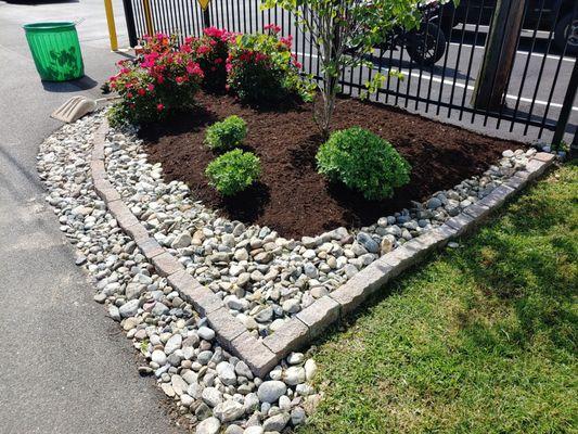 Turned it into truck friendly edges, and added low maintenance plants and small shade tree. Turn it green!