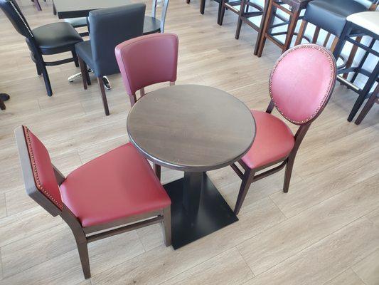 Three upholstered restaurant chairs in red and wood table in walnut finish