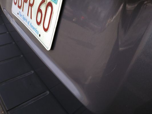 Photo back of Ford Escape near plate still have scratch after the hand wax job.