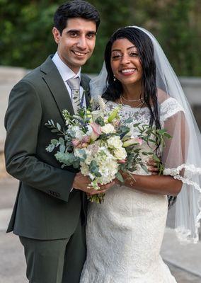 A newly married couple holding a bouquet