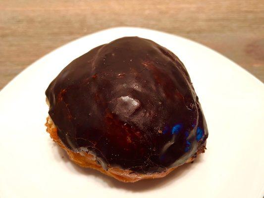 Cream-Filled Chocolate-Iced. Raised donut is infused with vanilla custard cream and topped with a chocolate frosting.